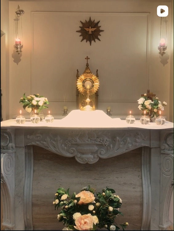 Altar preparado con flores y cirios para una ceremonia acompañada por el coro